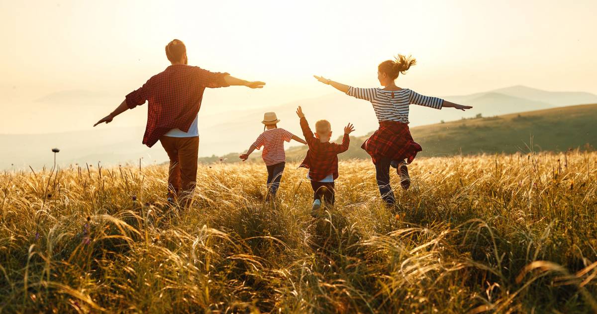 Gelukkige familie: moeder, vader, kinderen, zoon en dochter op zonsondergang.