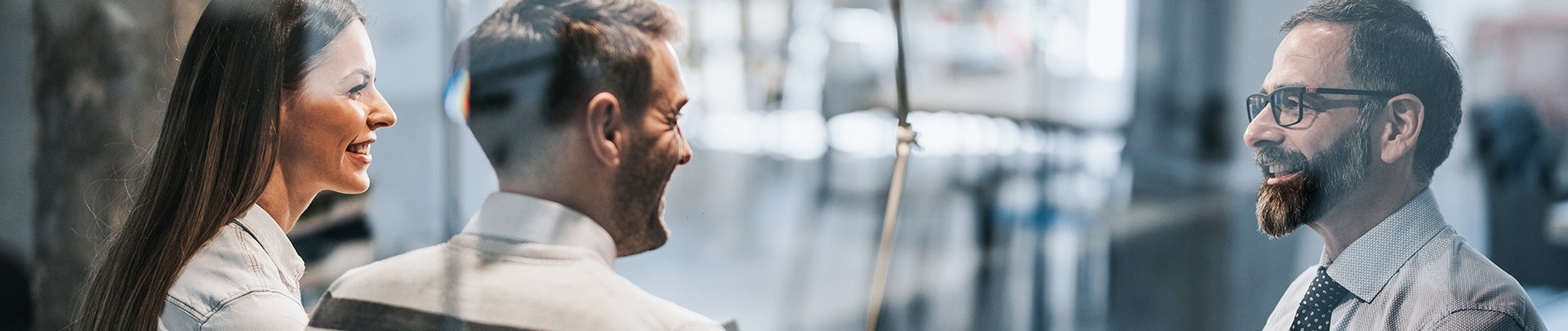 Gelukkige paar schudden handen met kredietagent in het kantoor