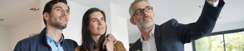 Een man en vrouw bezichtigen een woning samen met een mannelijke makelaar